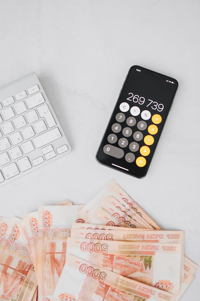 Image of a smartphone calculator and Russian rubles on a desk, related to finance and budgeting.